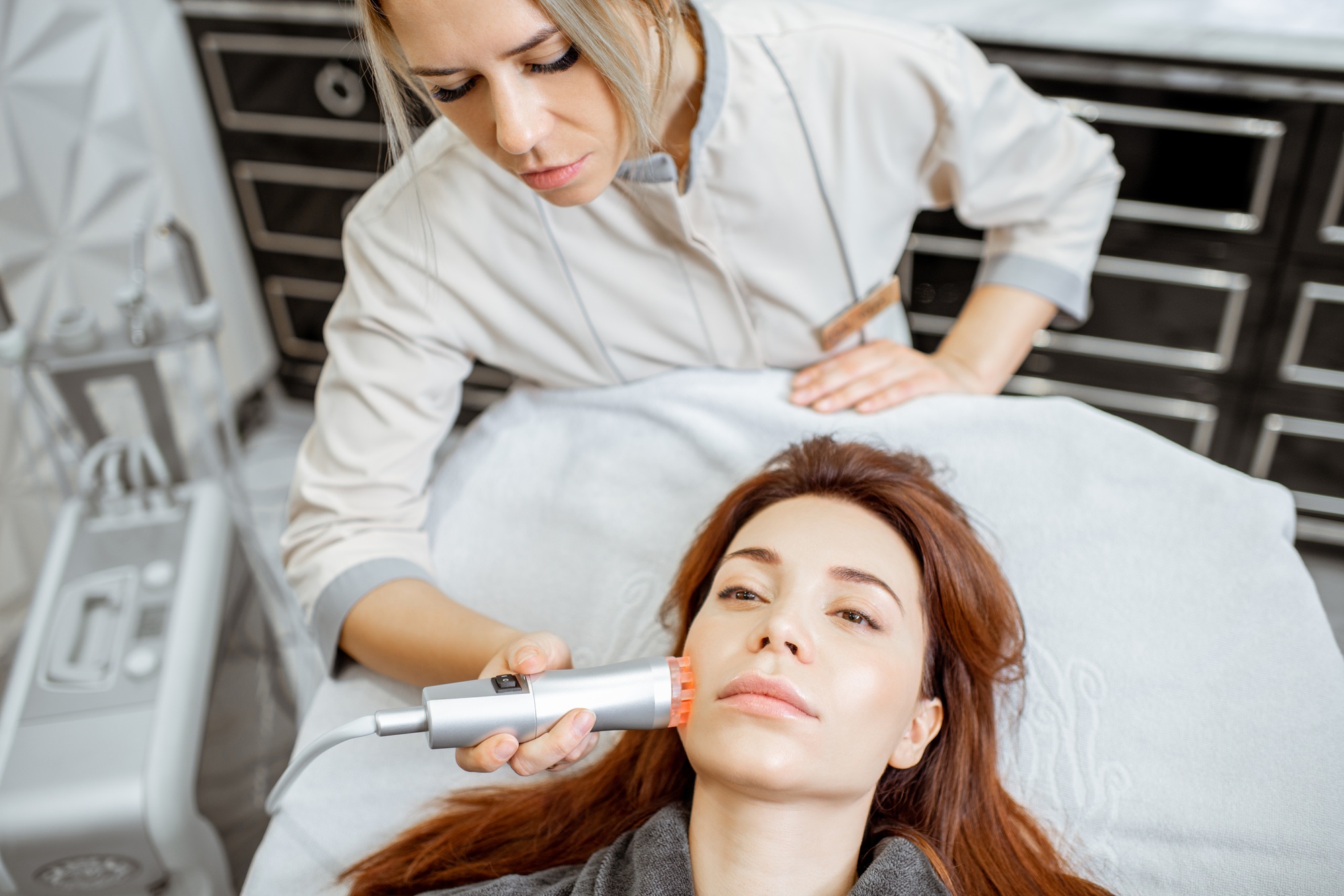 Cosmetologist making facial treatment to a woman
